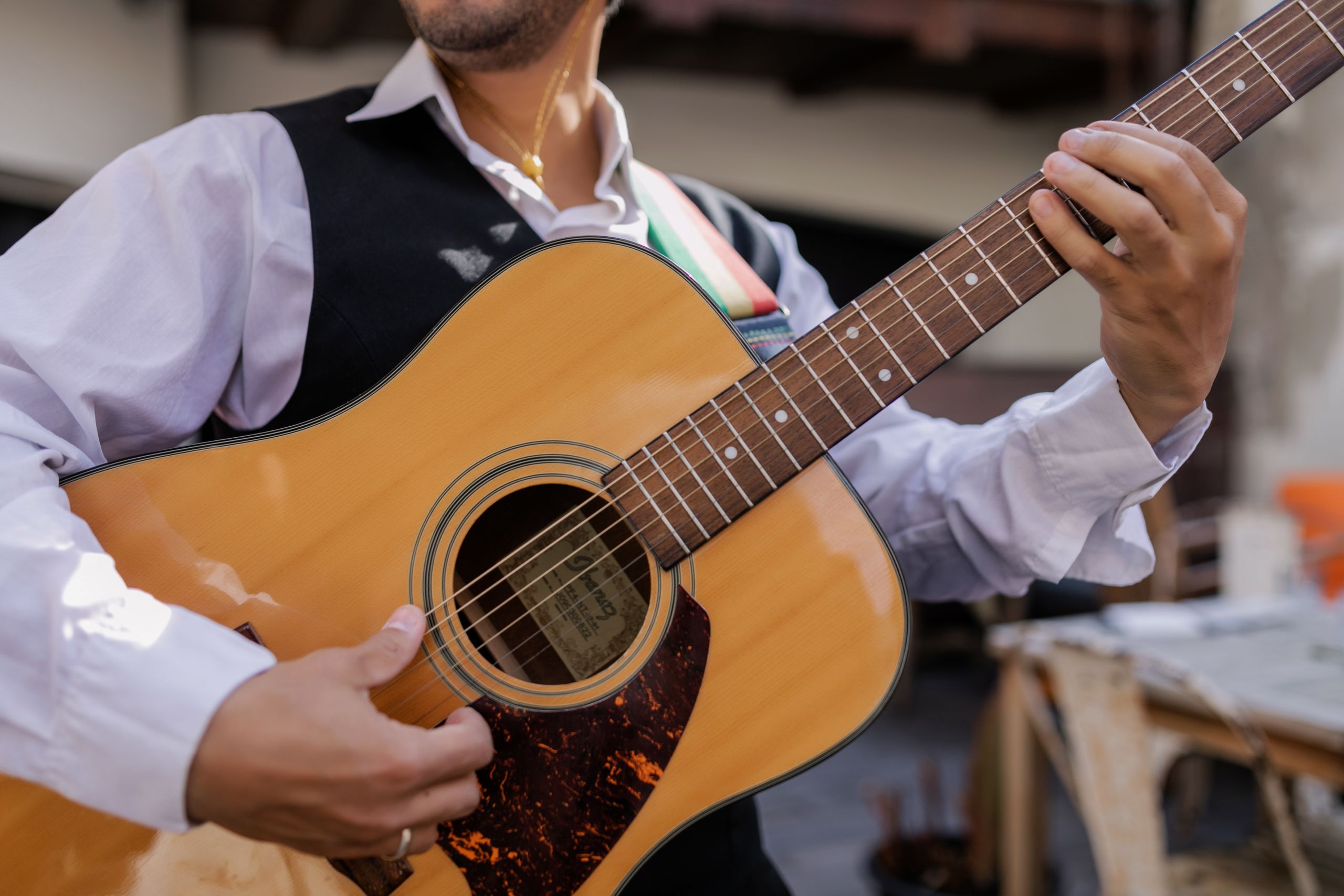 A musician playing an acoustic guitar, showcasing detailed hand movements and instrument craftsmanship.